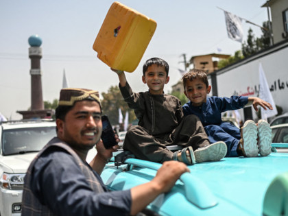 Taliban supporters carry a dummy yellow canister, intended to contain homemade explosives,