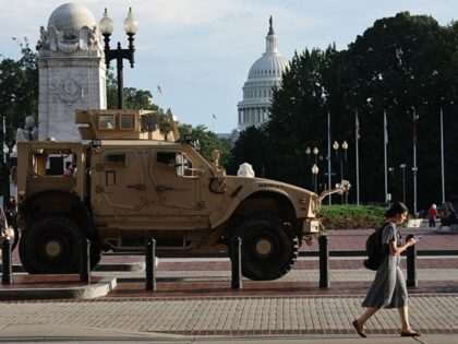WASHINGTON, DC - AUGUST 14: Pedestrians pass an MRAP (Mine Resistant Ambush Protected Vehi