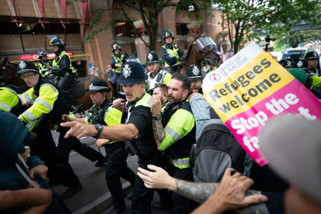 Mounted police officers scuffle with demonstrators during a protest by Abolish Asylum Syst