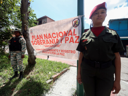 A member of the presidential guard (R) stands guard during an orientation day for people w