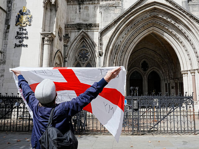A protester holds up a St George's cross flag with the slogan "Get Off My Land&q