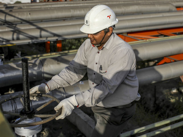 An employee turns a hand wheel at the Vadinar Refinery complex operated by Nayare Energy L