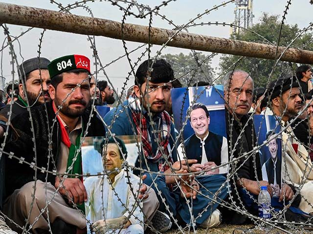 Supporters of jailed former prime minister Imran Khan hold his posters during a gathering