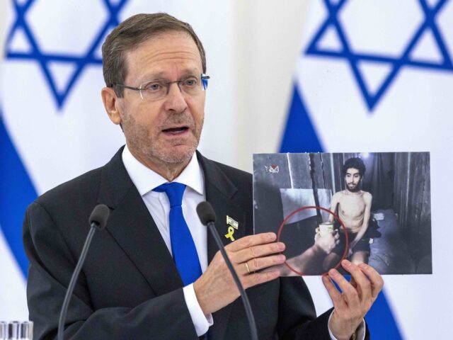 Israel's President Isaac Herzog shows photos of Israeli citizens imprisoned in the Ga