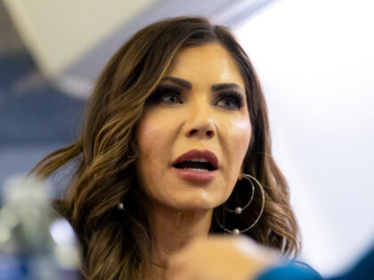 U.S. Homeland Security Secretary Kristi Noem speaks with a reporter on her plane while en