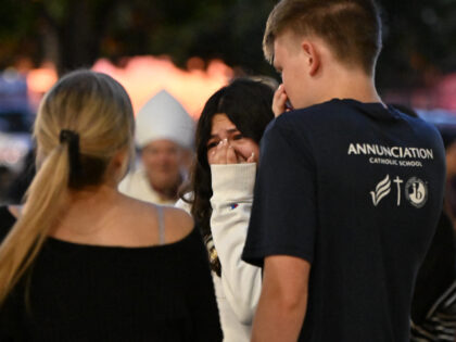 Mourners gather during a vigil at Academy of Holy Angels in Richfield, Minnesota, for the