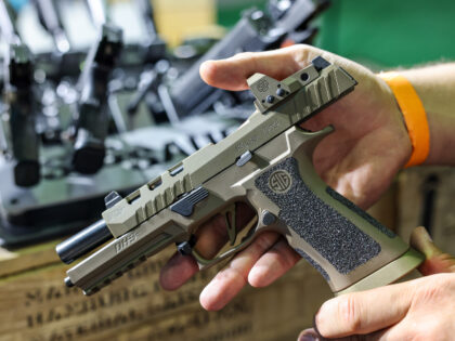 27 September 2024, Saxony, Leipzig: A man shows a SIG Sauer P320 DH3 pistol at the stand o