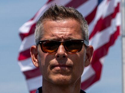 Sean Duffy stands in front of a flag
