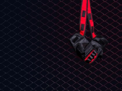 Gloves for MMA hang on nail on a black background.