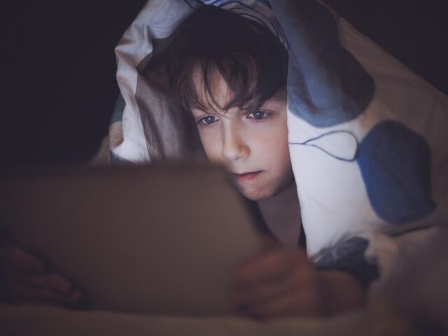 Teen sneaking tablet access in bed