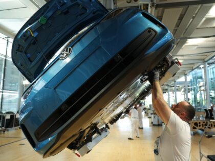 VW factory worker assembles an EV