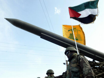 Lebanese Shiite Hezbollah militants parade with a missile as the Palestinian (R) and the m
