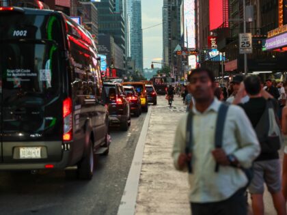 NEW YORK, NEW YORK - JULY 12: People take photographs of the sunset at 42nd Street in Time
