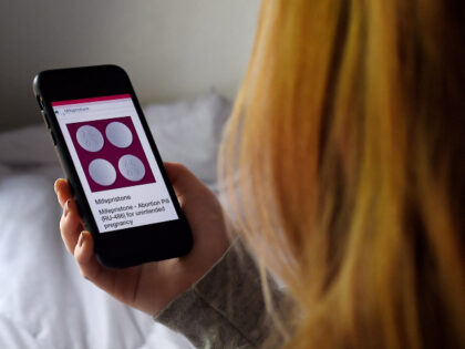In this photo illustration, a person looks at an Abortion Pill (RU-486) for unintended pre