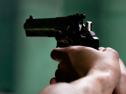 Person Holding Black Revolver in Bokeh Photography