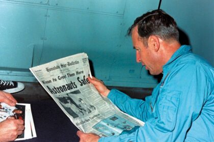 Astronaut Jim Lovell reads the news after his crew returned safely to Earth from a failed