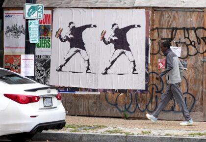 Banksy-style posters of a protester throwing a sandwich, like a Molotov cocktail, in Washi