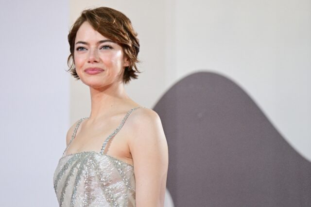 Emma Stone poses on the red carpet before the premiere of 'Bugonia'