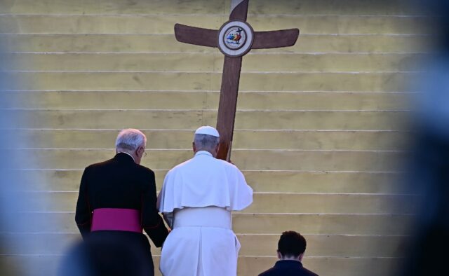The pope took to the stage carrying a large wood cross