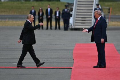US President Donald Trump greets Russian President Vladimir Putin on the tarmac after they