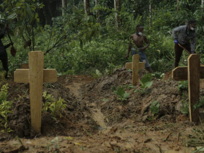 EDITORS NOTE: Graphic content / Crosses are seen as volunteers dig graves for the victims