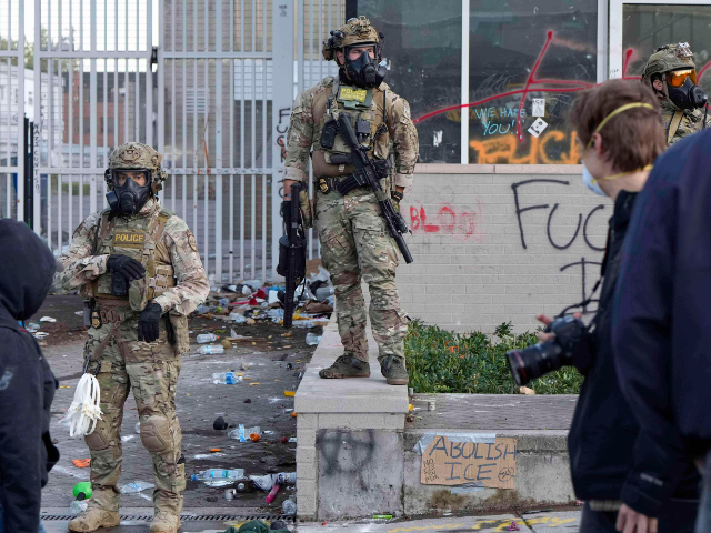 AP25199028420306 U.S. Customs and Border Protection agents look on outside the U.S. Immigration and Customs