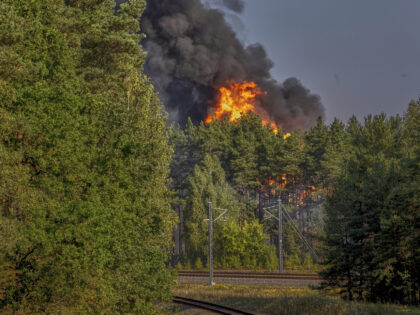 Smoke and flames rise following powerful explosions after several rail cars loaded with li