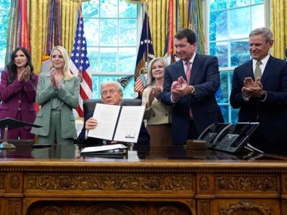 Title: Trump Image ID: 25258777858516 Article: President Donald Trump holds a signed memor