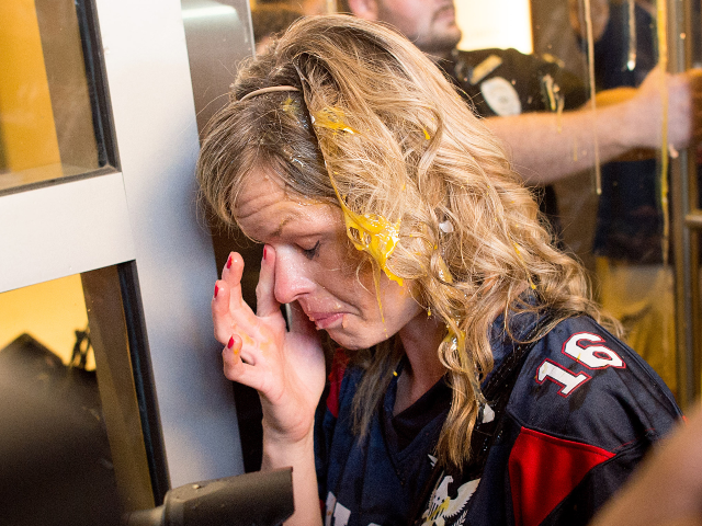 AP497860005643 A woman wipes egg off her face after being pursued by protesters while leaving Republican