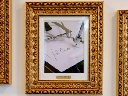 Alternate Crop) Framed portraits of U.S. President Donald Trump flank an image of former U