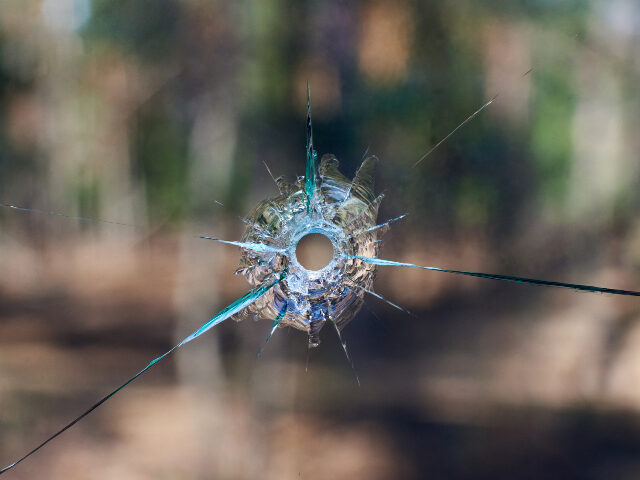 bullet hole in glass close up on blurred nature background.