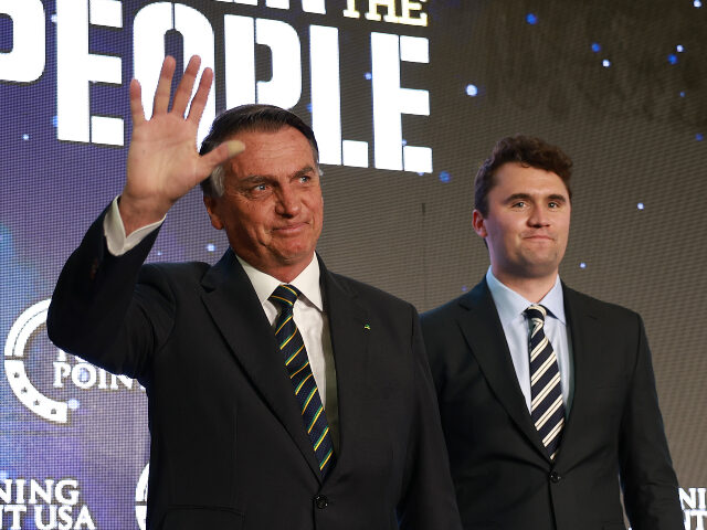 Charlie Kirk (R) and Jair Bolsonaro Far-right former Brazilian President Jair Bolsonaro waves as he stands with Charlie Kirk,