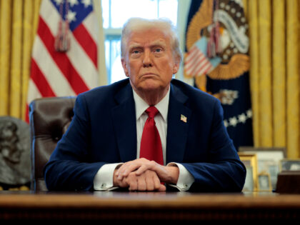 U.S. President Donald Trump talks to reporters from the Resolute Desk after signing an exe