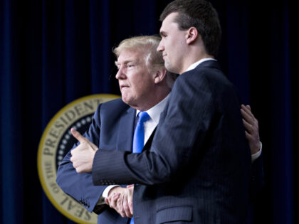 U.S. President Donald Trump, left, shakes hands with moderator Charlie Kirk after a discus