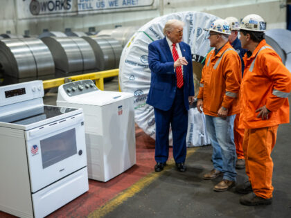 President Donald Trump speaks with workers before delivering remarks on a partnership deal