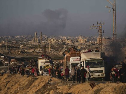 Displaced Palestinians fleeing northern Gaza carry their belongings along the coastal road