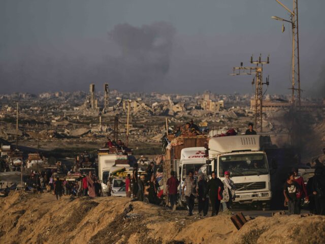 Displaced Palestinians fleeing northern Gaza carry their belongings along the coastal road