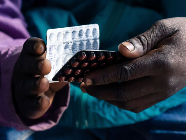 GettyImages-1156418512 Blessing Chingwaru, 29, an HIV positive TB patient, holds a packet of tablets received as