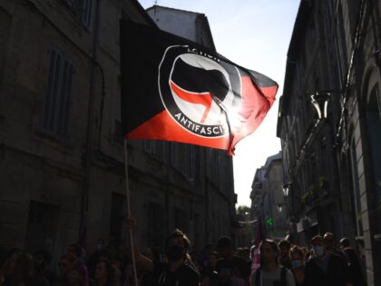 A protester waves the anti-fascist movement flag "Action antifasciste" during a rally agai