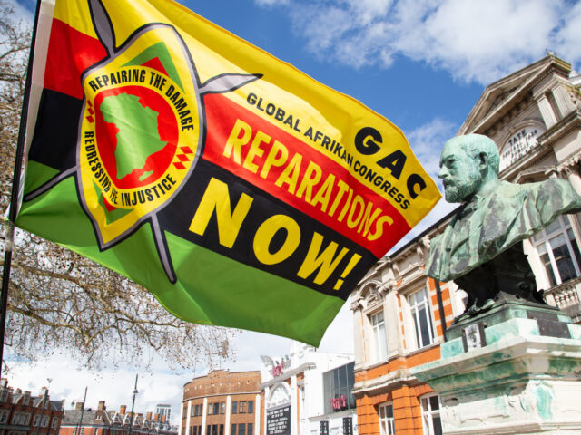 LONDON, UNITED KINGDOM - 2023/04/06: A man holds a flag calling for reparations in Windrus