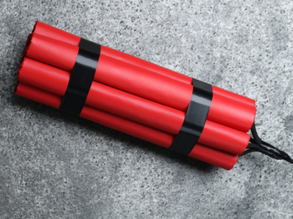 Dynamite bomb on grey table, top view.