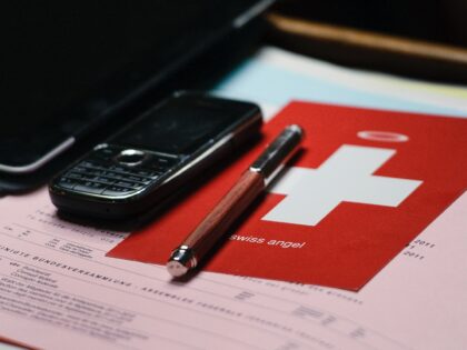 A postcard showing a Swiss flag with a halo on the top is seen at the desk of member of Pa