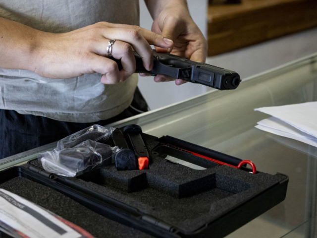 GettyImages-1771429276 A customer holds a handgun for sale at a store in Miami Beach, Florida, US, on Monday, Oct