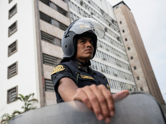 A police officer looks on as he stands guard at the National Prosecutor's headquarters bui