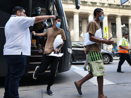 Migrants are led from one bus to another bus after arriving from Texas at Union Station in