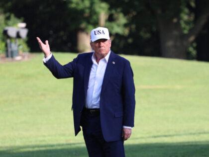 US President Donald Trump stops to gesture at the US flag as he walks on the South Lawn fr