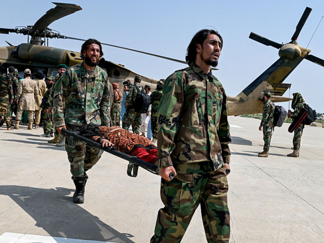 GettyImages-2232577010 Taliban security personnel carry an earthquake victim evacuated by a military helicopter f