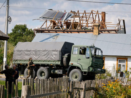 Police and army inspect damage to a house destroyed by debris from a shot down Russian dro