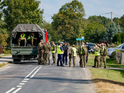 Police and army gather to inspect a house destroyed by debris from a shot down Russian dro