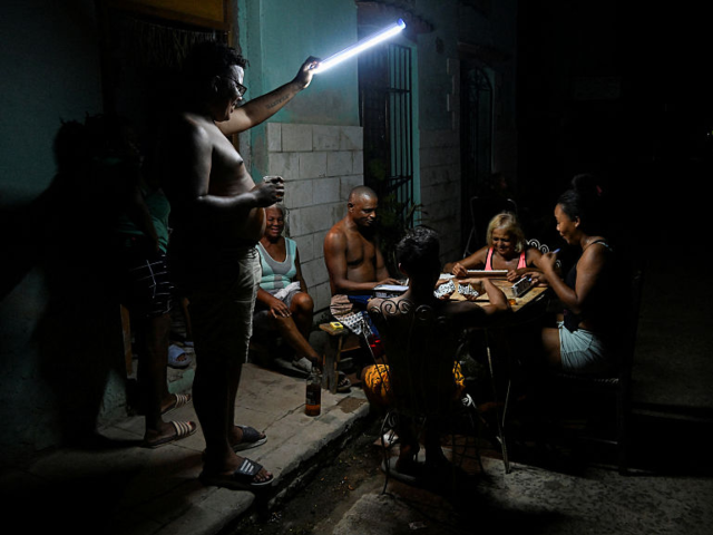 People play domino on the street during a blackout in Havana on September 10, 2025. Cubans